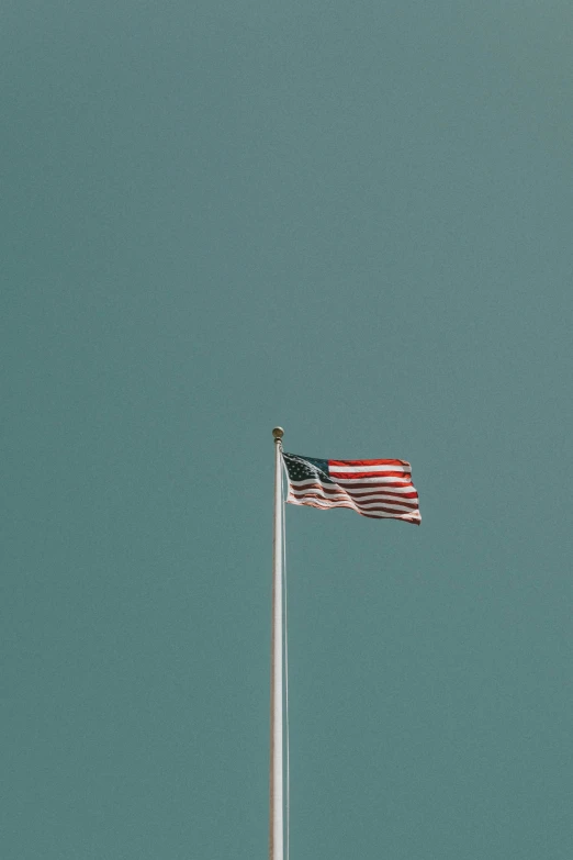 a small american flag is blowing in the wind