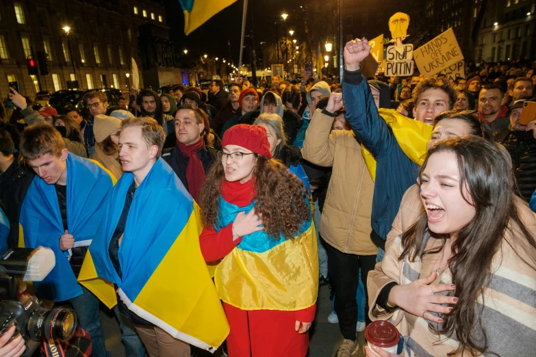 large group of people standing outside and one person holding a sign