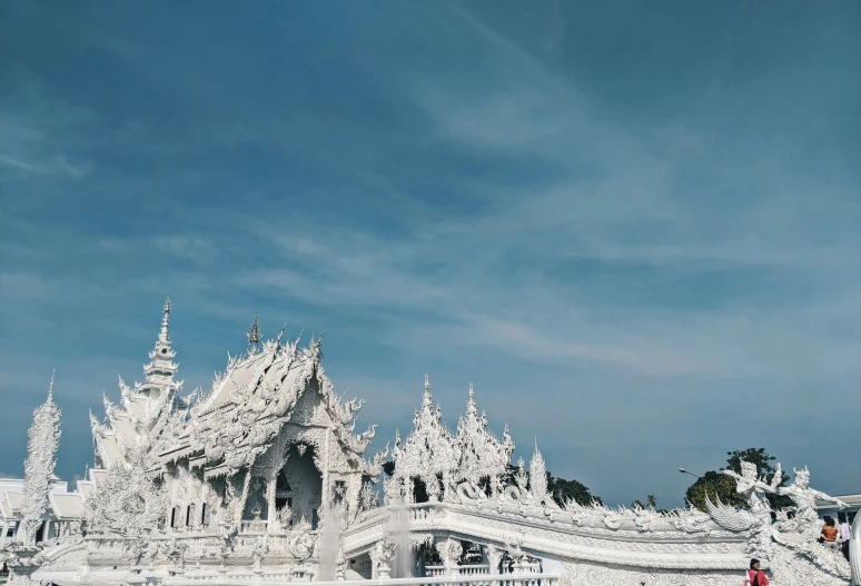 a couple in white walking together in front of a big building