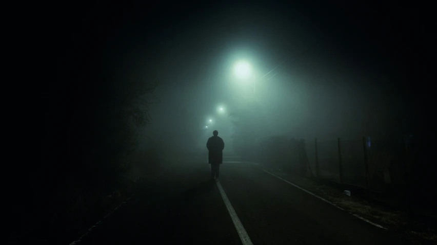 a man is walking down a street at night