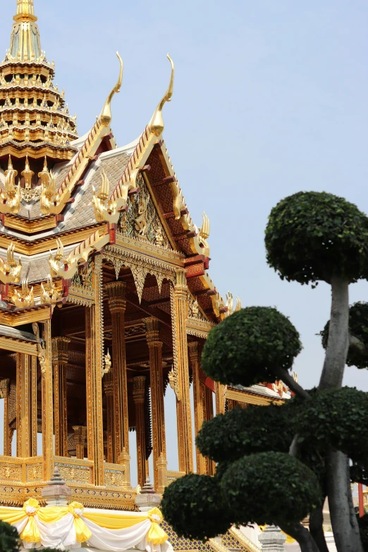 the pagoda is made out of wood, and has a golden roof