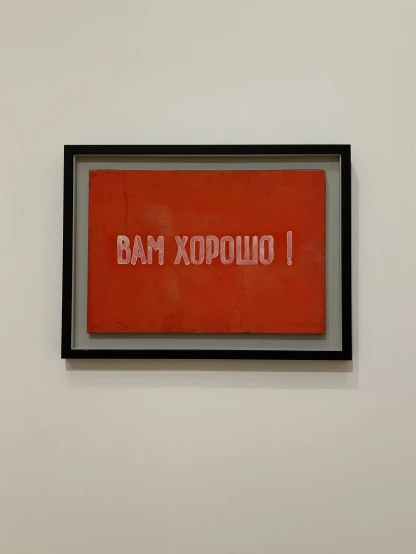 red text on white wall with black framing