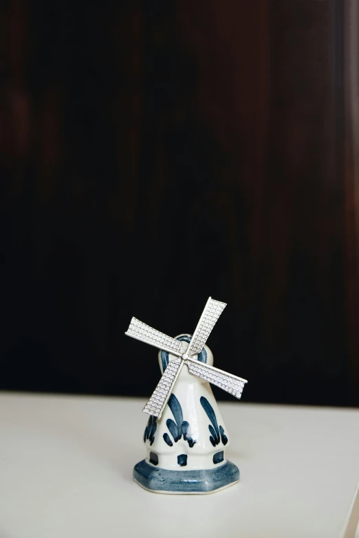 there is a small white ceramic sculpture that resembles a windmill