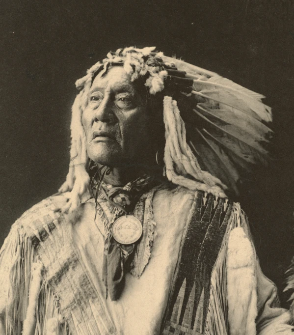 a native american in traditional dress and a badge