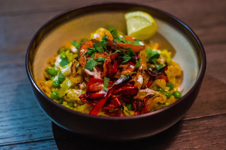 a close up of a bowl with food and a slice of lime