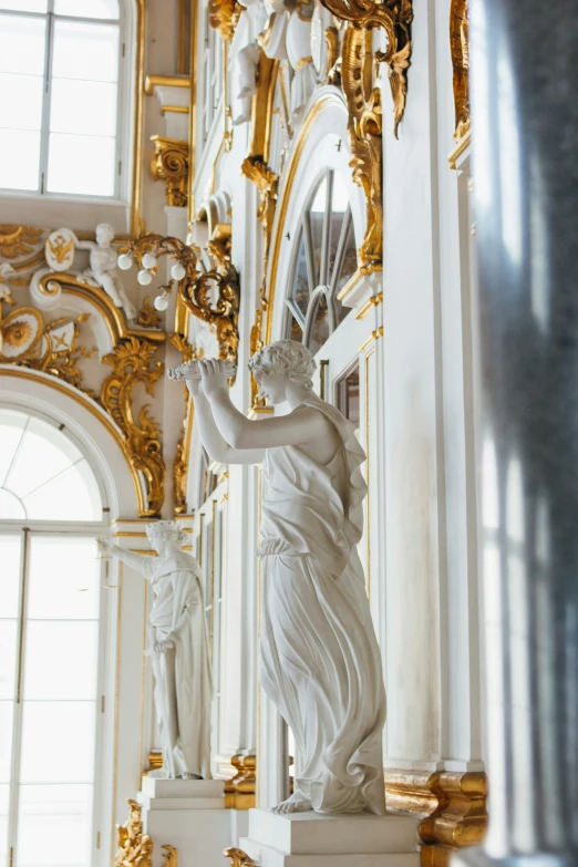 a white and gold - tone sculpture in the center of an ornate building