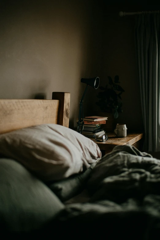 a view of an unmade bed with books and some lights