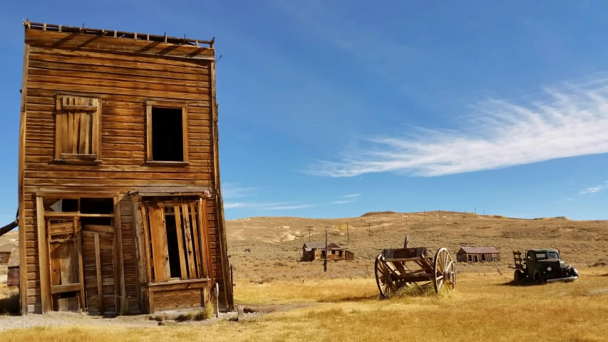 an old building sits in a field near another building