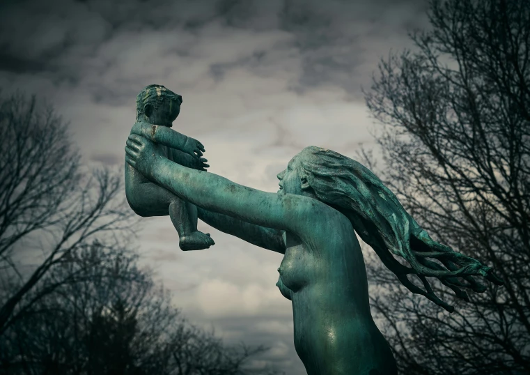 a bronze statue of a woman holding a baby