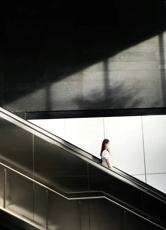 a person on an escalator under some lights