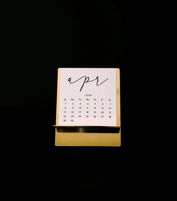 a calendar and pen on a black surface