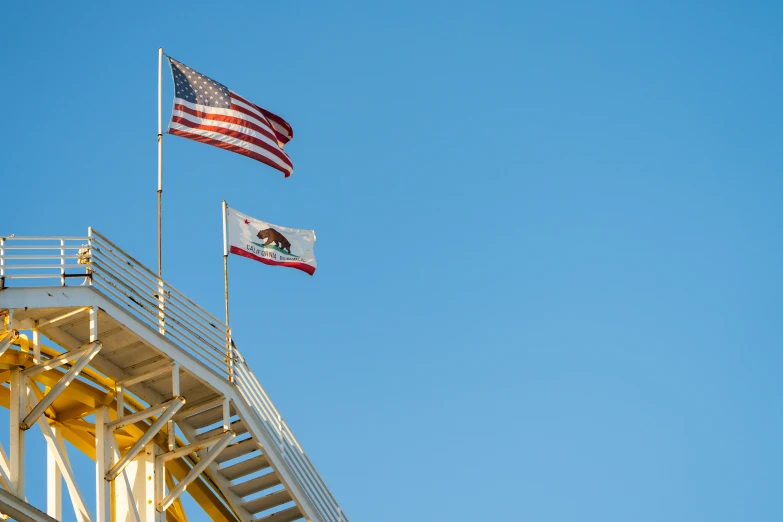 a flag flies next to an american flag on the side of a building