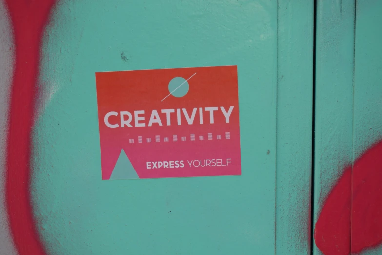 a sticker on a painted steel object with some red paint