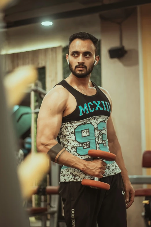 man in gym vest holding two large objects