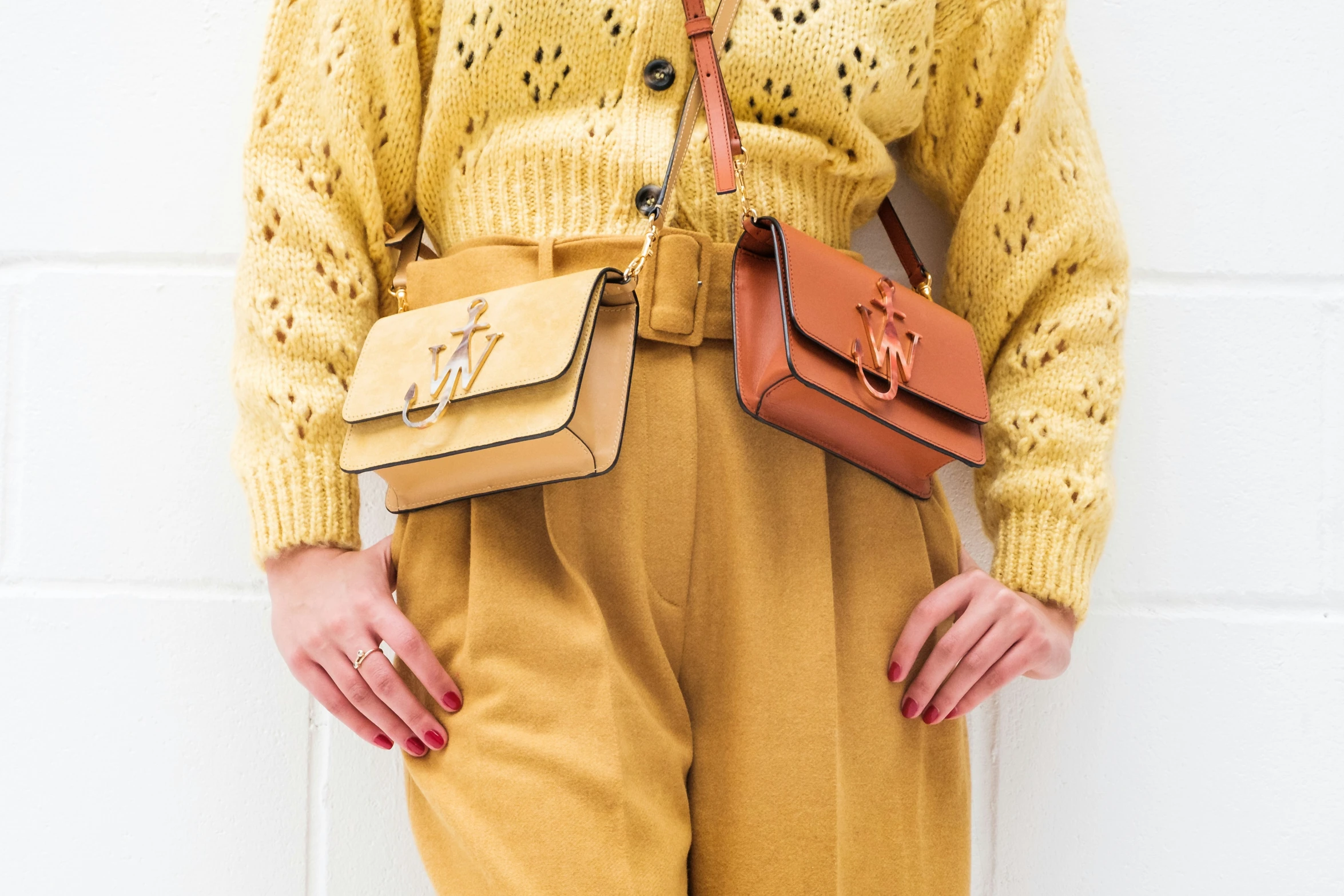 a person with a yellow sweater holding two bags