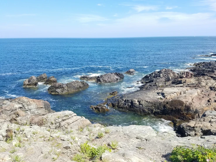 a rocky shore surrounded by blue water