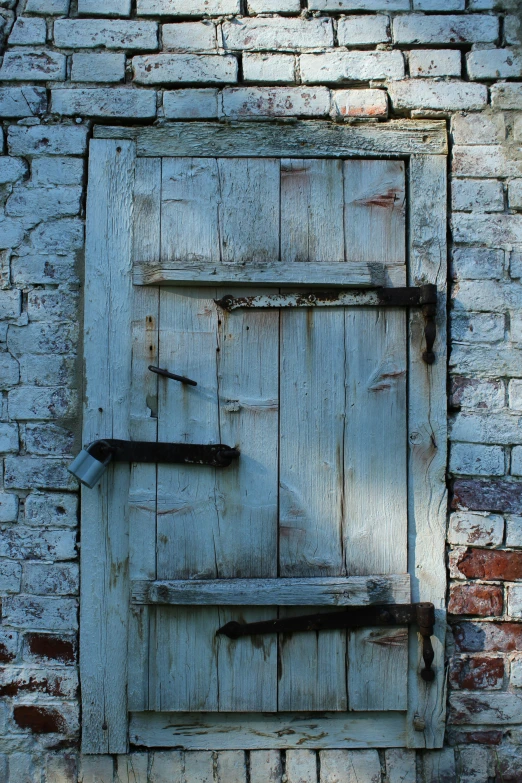 an old door with a broken shelf and brick walls