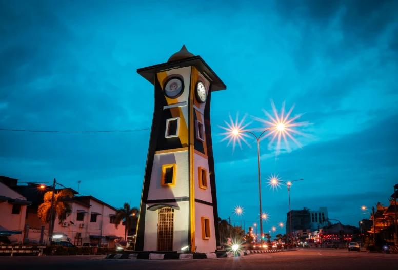 large clock tower near street at night time