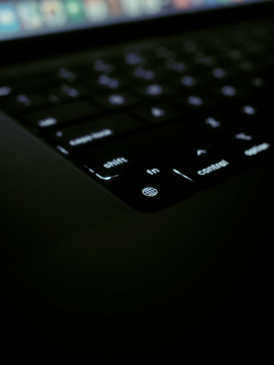 the keyboard of a laptop in a dark room