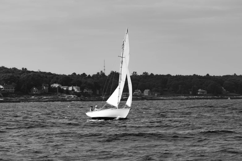 a sailboat sailing through the ocean with its sails down