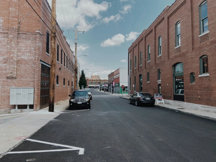 two cars are parked along an empty street