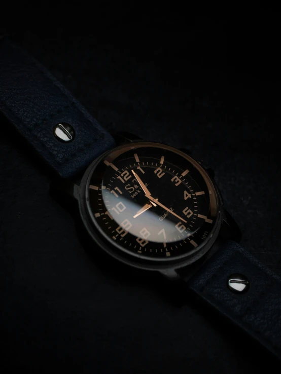 an analog watch with a leather band and a dark background