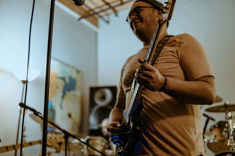 a man playing on an electric guitar in a music studio