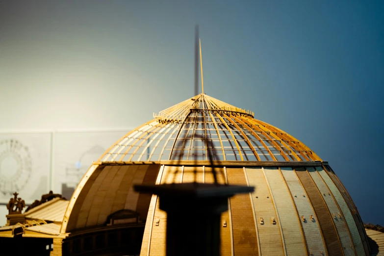 a tall building with a metal roof in the middle of a clear sky