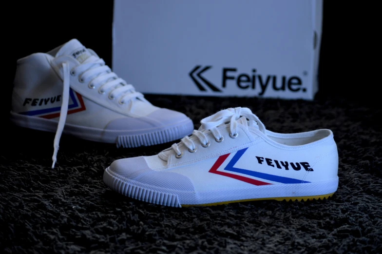 white tennis shoes with red, blue and yellow letters and an felvyue logo