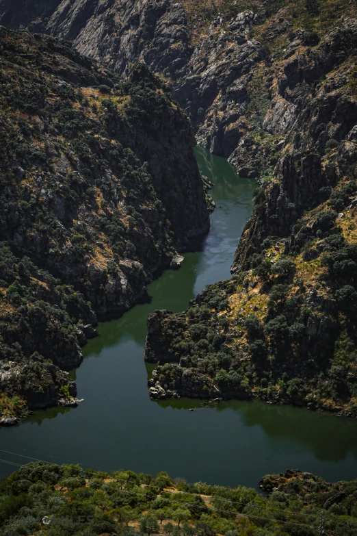 an aerial view of a valley on the edge of mountains