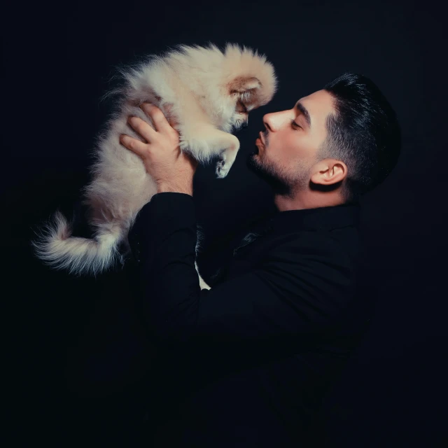 a man holding a dog that is white