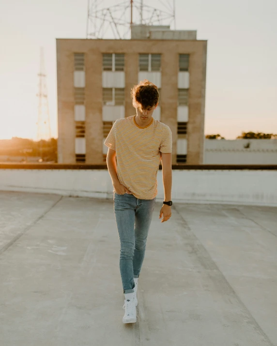 a young woman in jeans walking on an outdoor rooftop