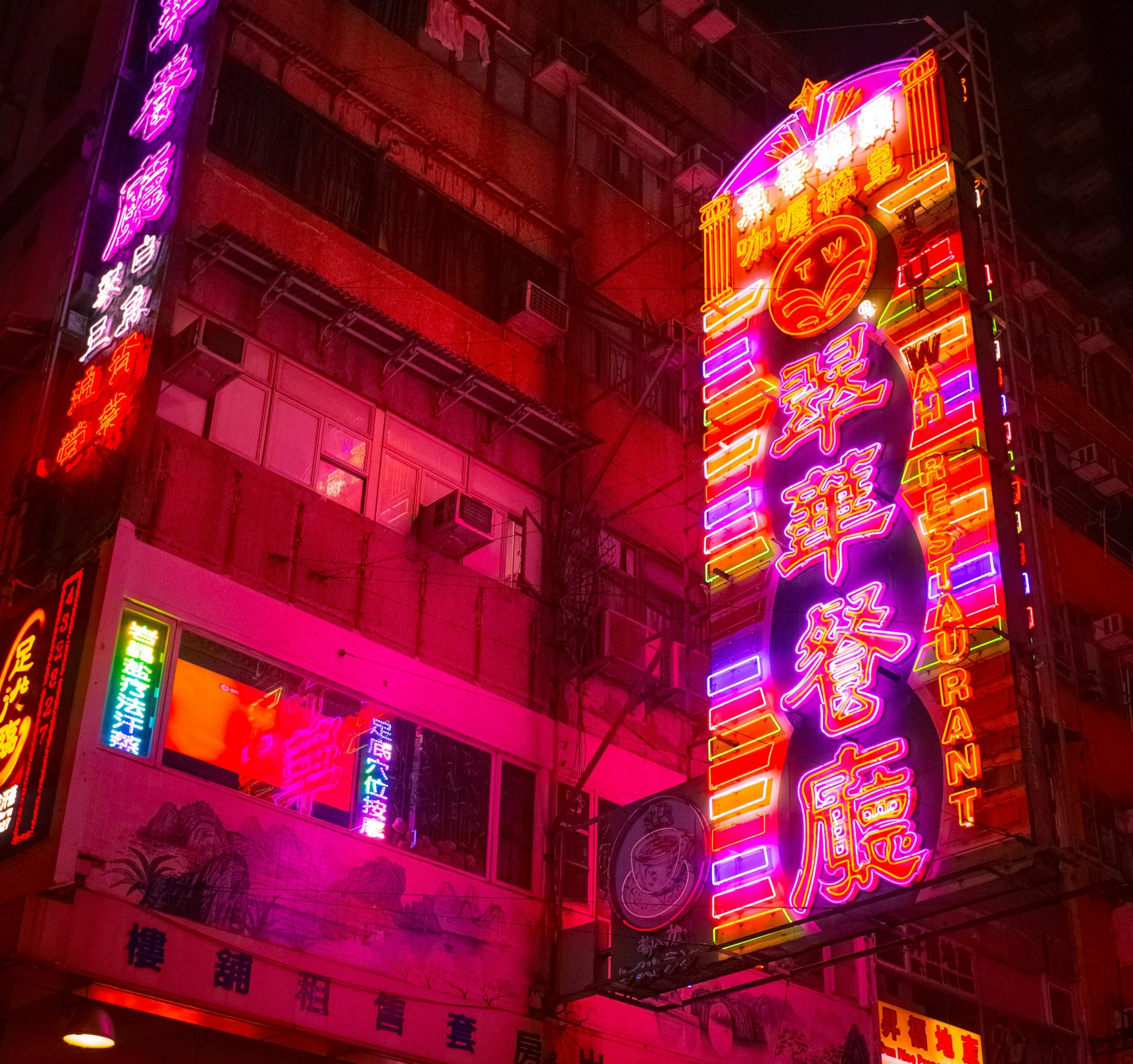 neon signs are lit up and lit up along a building