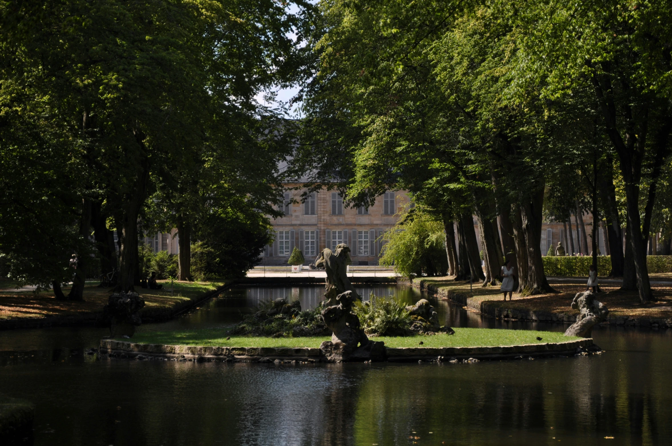 the gardens are very shady and the building is behind them