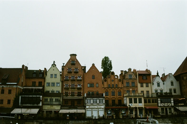 the skyline of some large buildings is shown against a grey sky