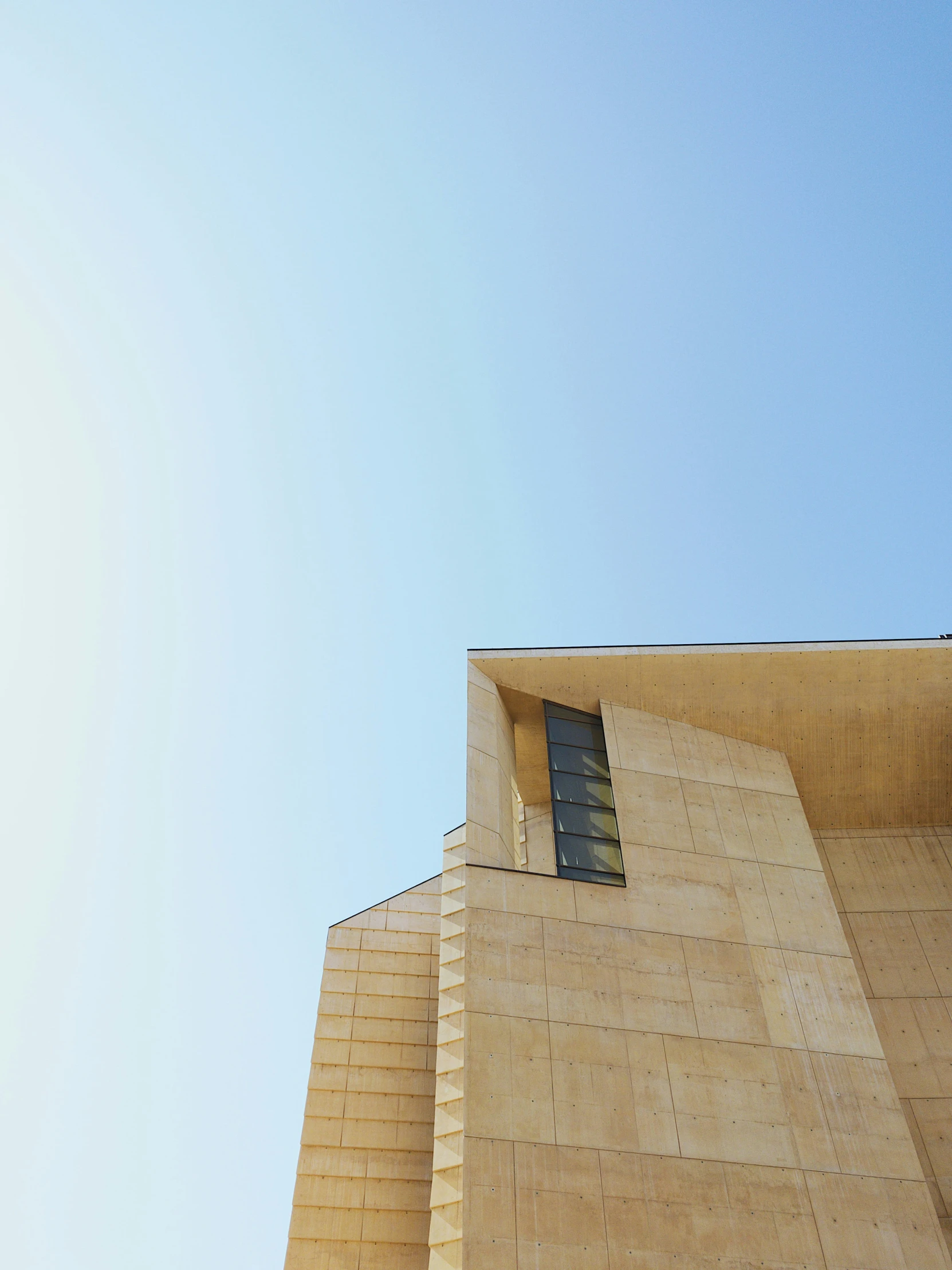 a tall building with a window in the top right corner