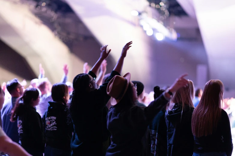 people standing in the audience raising their hands