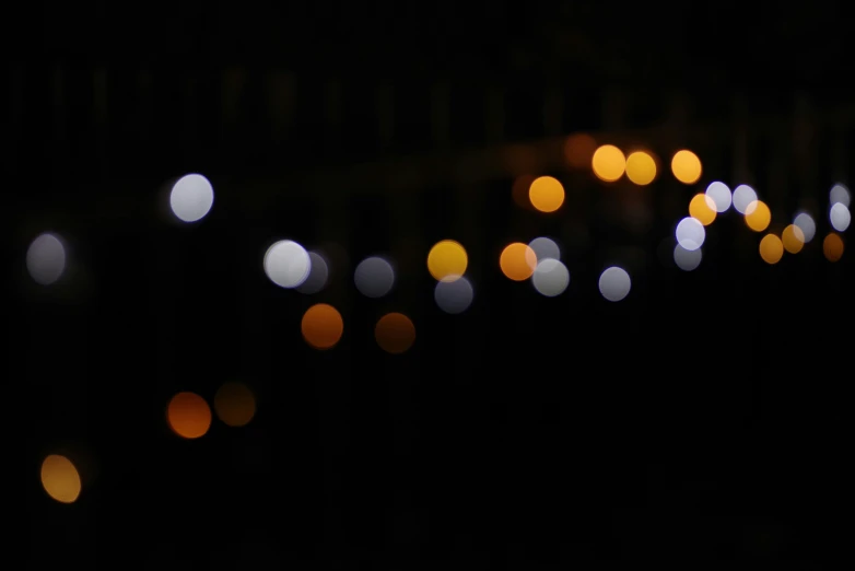 lights shining through a black sky on a street