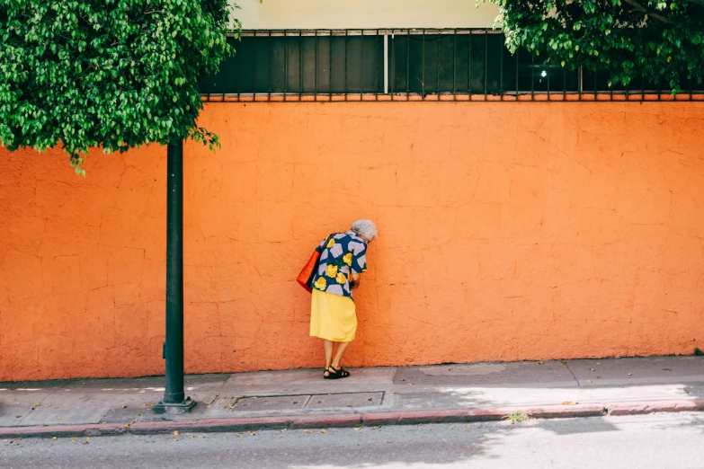 a woman standing next to a wall with a backpack on