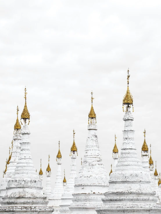 a set of six white buddhist buildings with gold domed towers