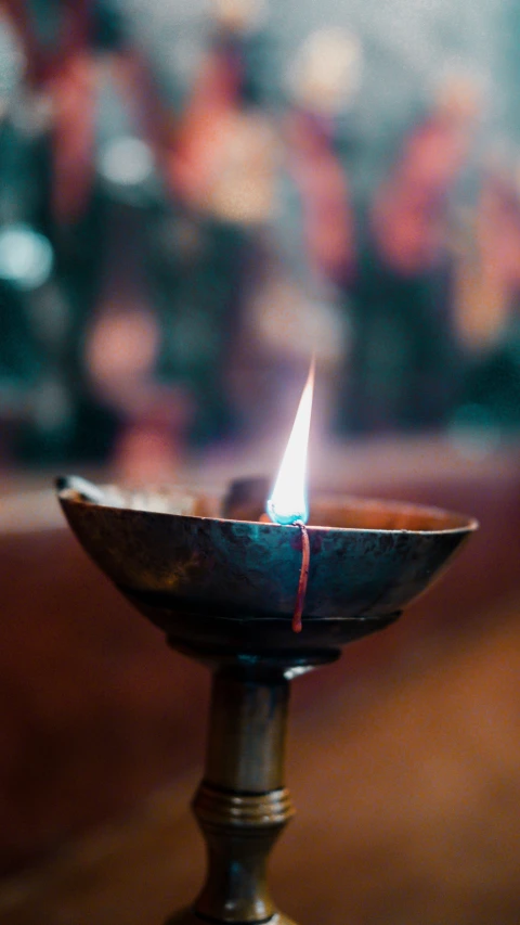 a candle is glowing on a small metal bowl