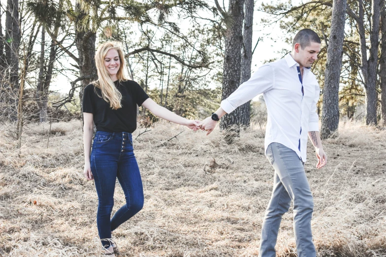 a man and woman walking in the woods together