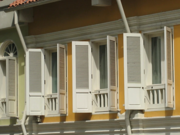 white wooden shutters of a house with orange painted walls