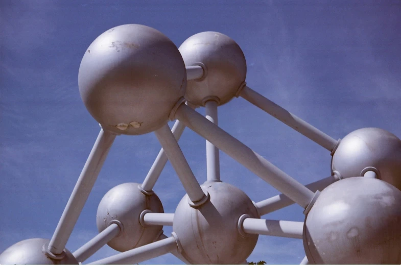 a structure with several large white balls in front of blue sky