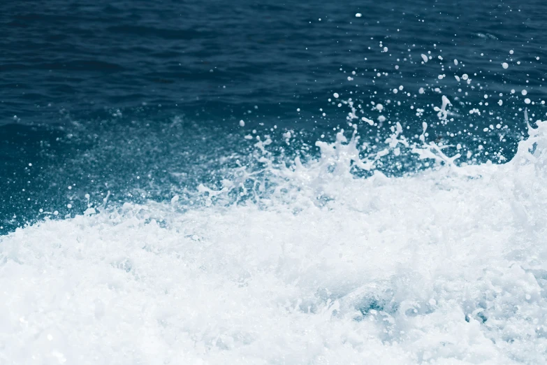 the foamy waves roll in on the water