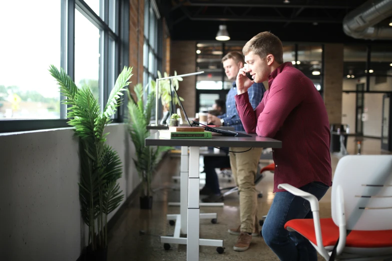 people standing at a table looking on a laptop