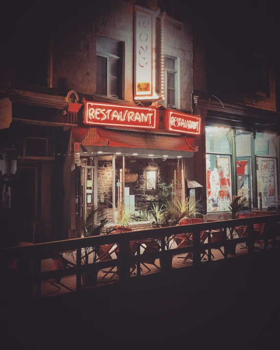 a restaurant with red signs and neon signs in the windows