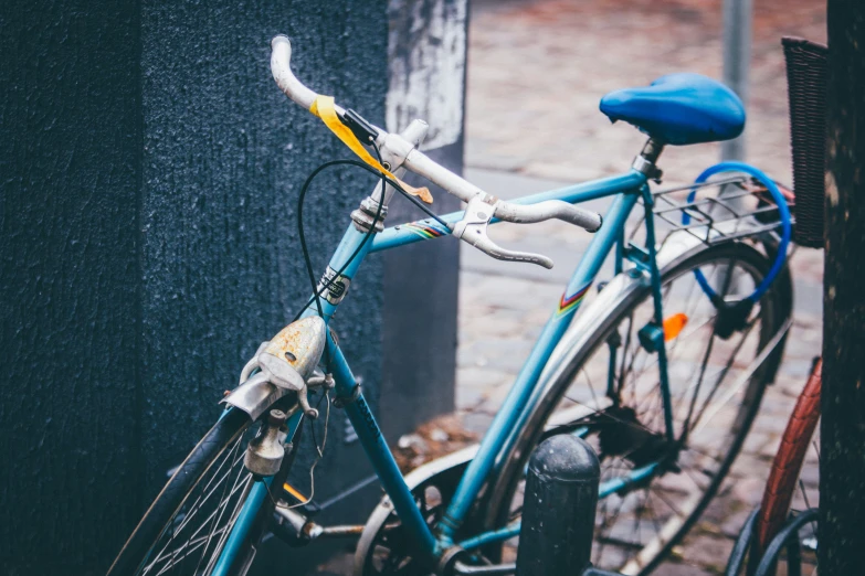 the back of a blue bicycle in front of a building