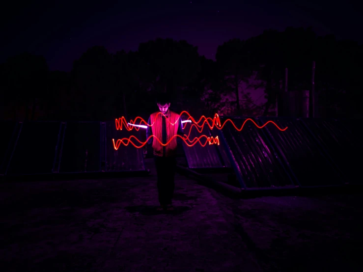 a person holding colorful lights in a dark area