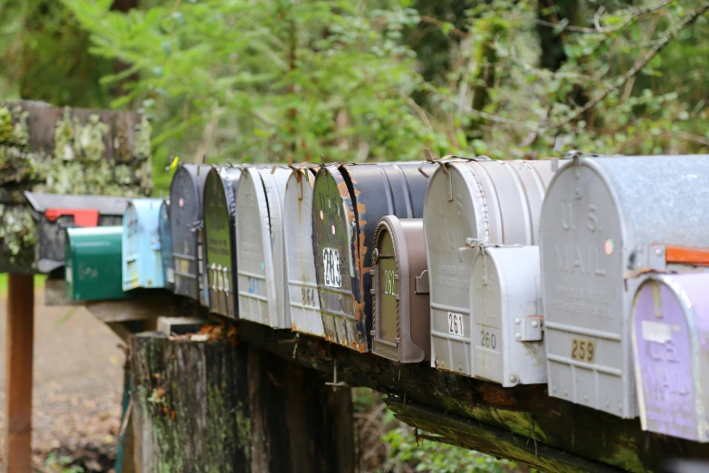 multiple mailboxes lined up on an old bridge